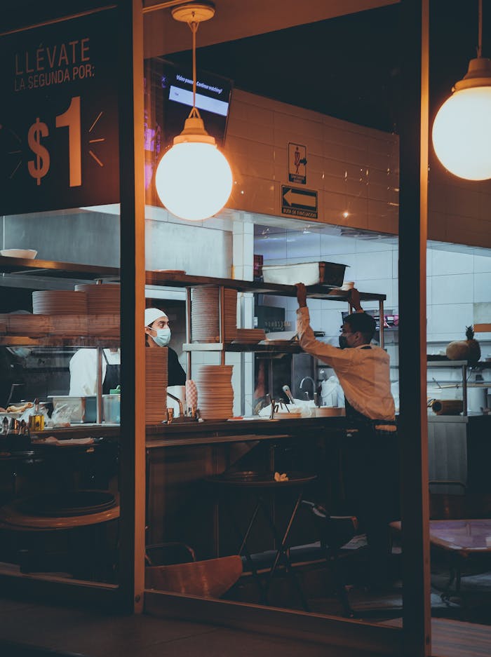 Chefs working in a restaurant kitchen at night, showcasing teamwork and culinary skill.