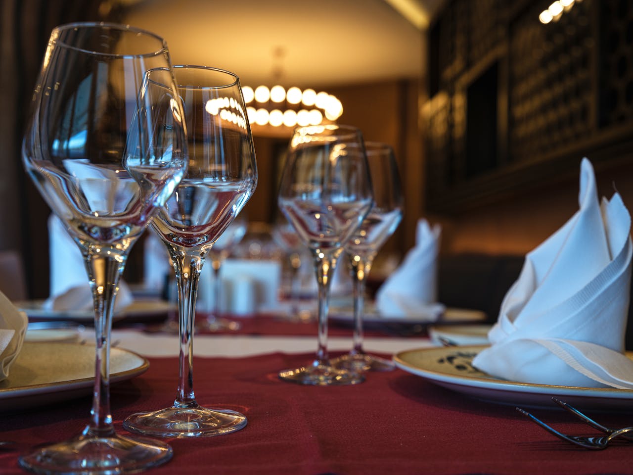 Close-up of a well-set dinner table with wine glasses and folded napkins, ready for a fine dining experience.