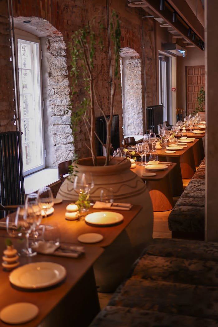 Elegant dining setup in a rustic room with stone walls and ambient lighting.