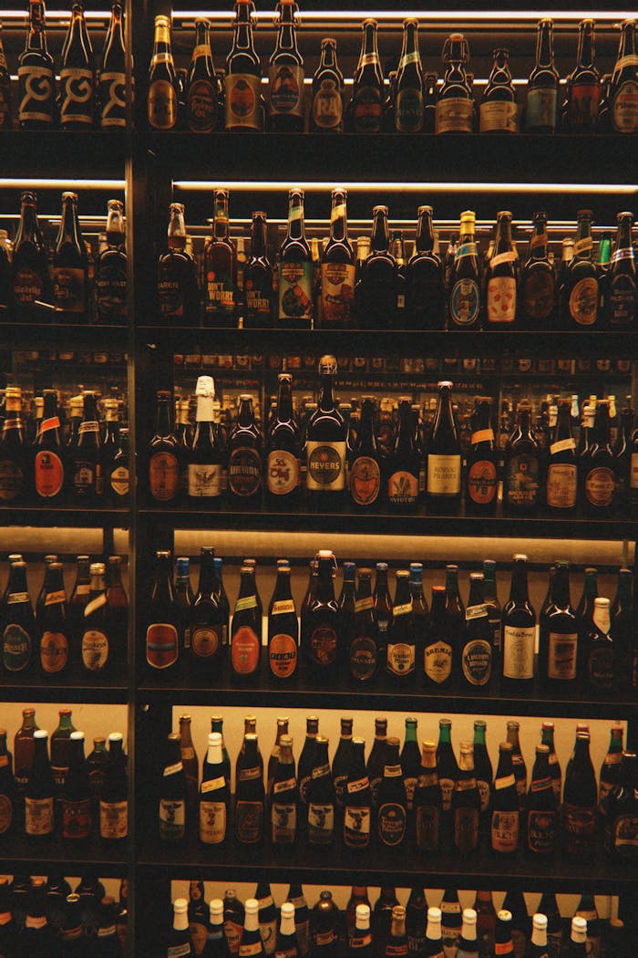 Services An extensive collection of diverse beer bottles displayed on shelves in a Copenhagen shop.