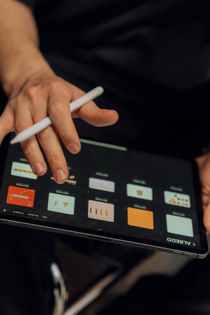 Services A person working on a digital tablet with a stylus, creating designs using an application.