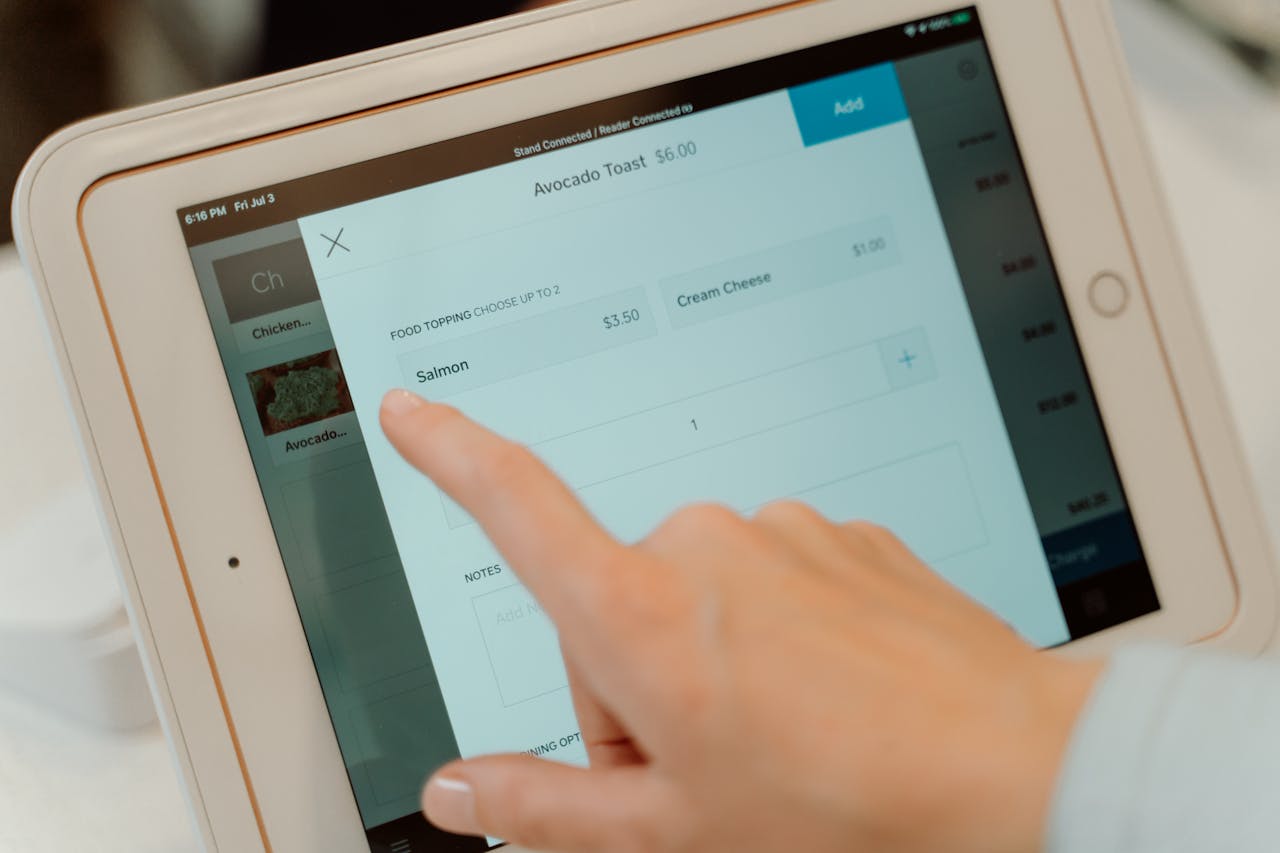 pexels photo 4921258 Close-up of a person's finger interacting with a point of sale tablet screen.